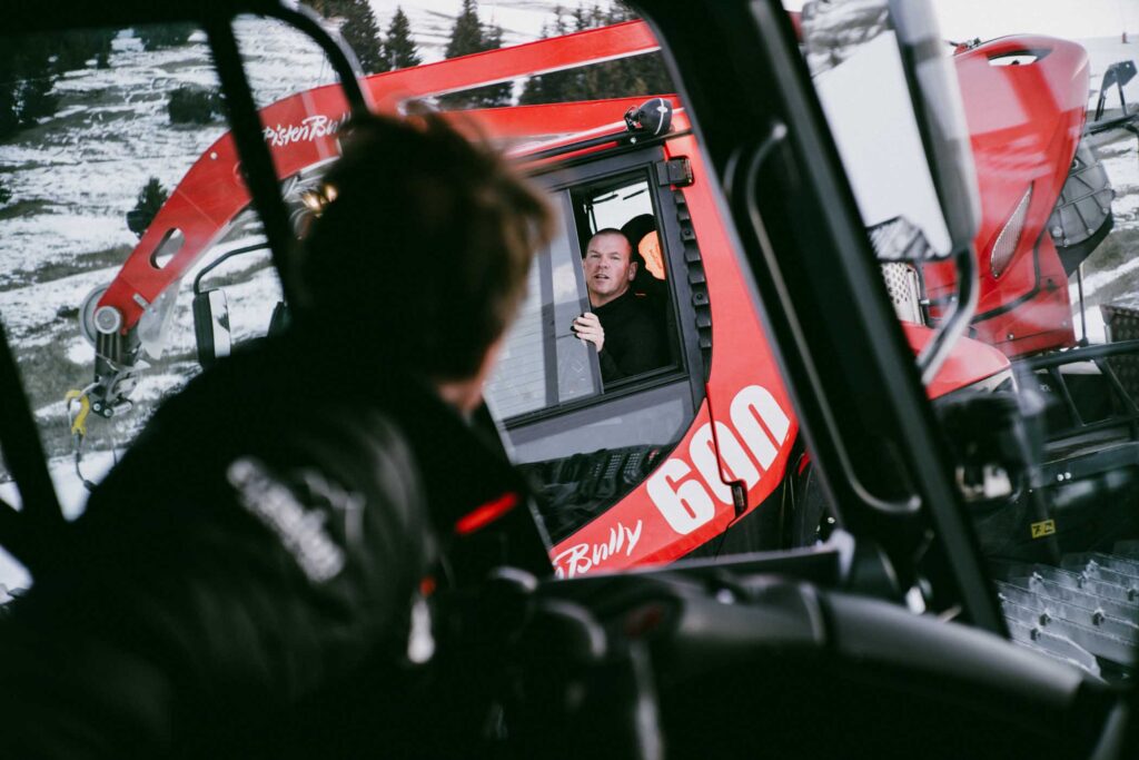two drivers of piste bashers talk through the windows