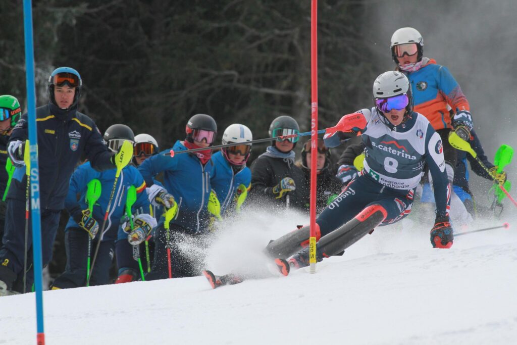 ski racer turns around gate, in front of audience, mouth open in concentration